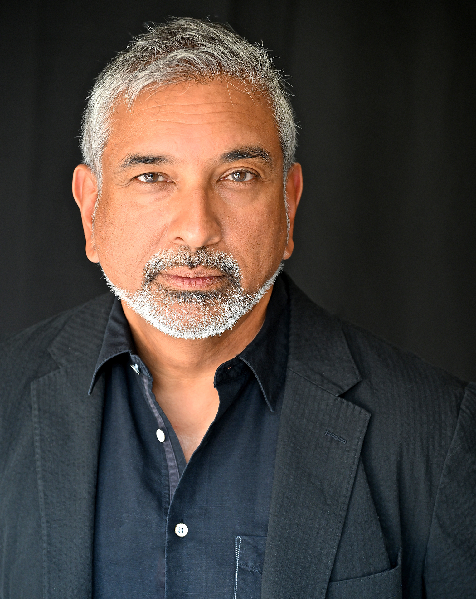 Man with grey hair wearing a dark jacket