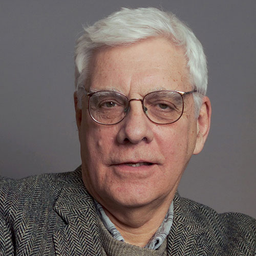 headshot of a man with white hair and glasses