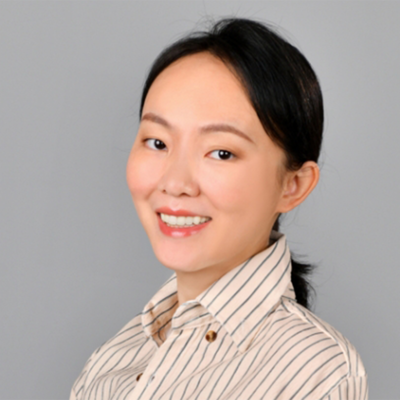 Person with shoulder-length dark hair wearingblack-rimmed glasses