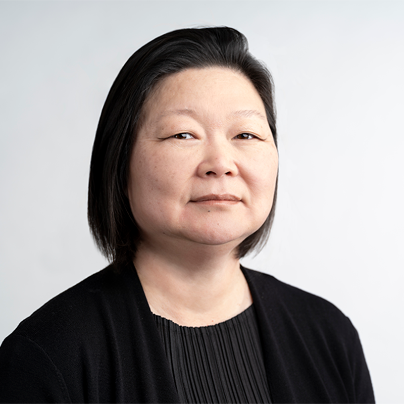 a woman with dark hair wearing all black with a white background