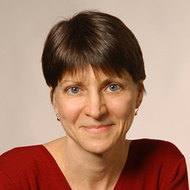 A person with short brown hair wearing a red sweater