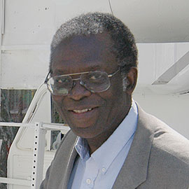 a man's face and shoulders wearing glasses and a sport coat
