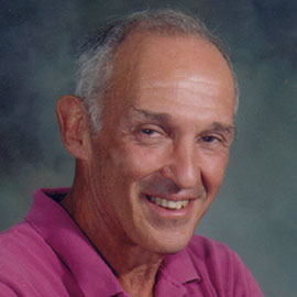 headshot of a man in a magenta shirt