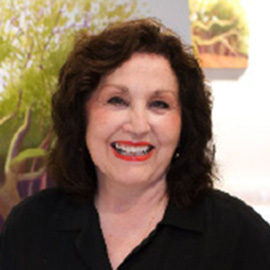 headshot of a woman with dark hair and a black shirt standing in front of a painting of trees