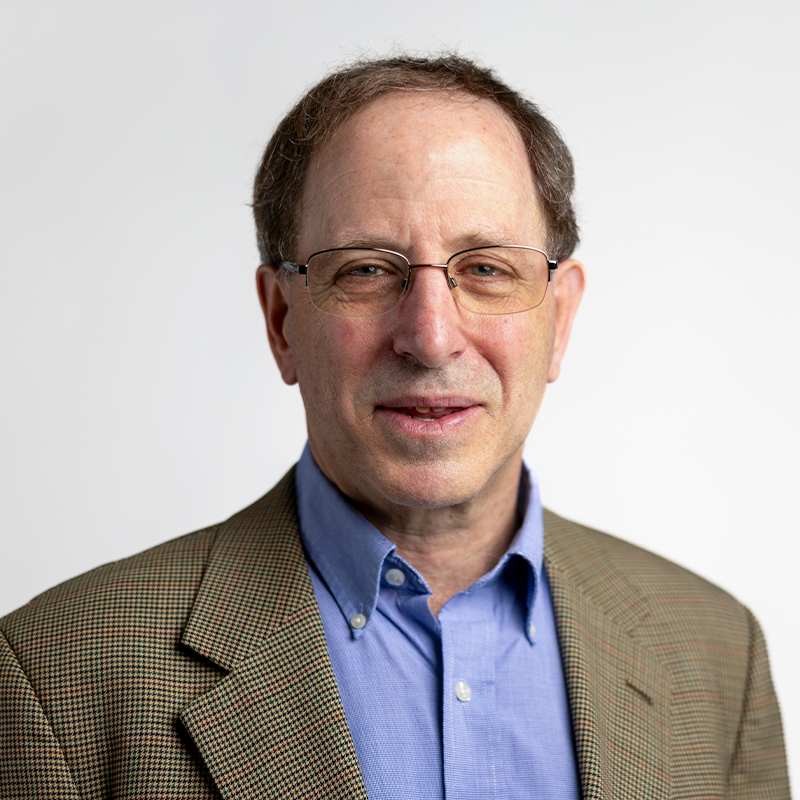 Man wearing glasses and a blue shirt and sport coat