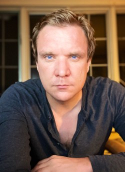 Photo of man in a black shirt.