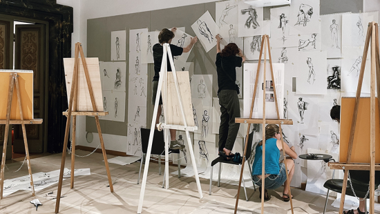 Students pinning up sketches in an art classroom