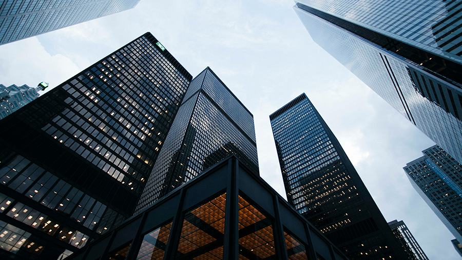 Looking upward at tall black skyscrapers