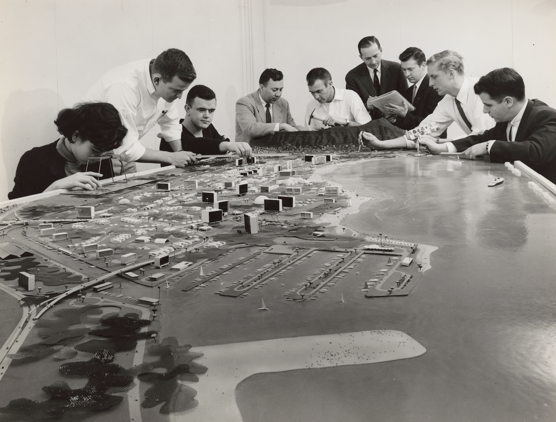 Historic image of people gathered around a large model of seaside community