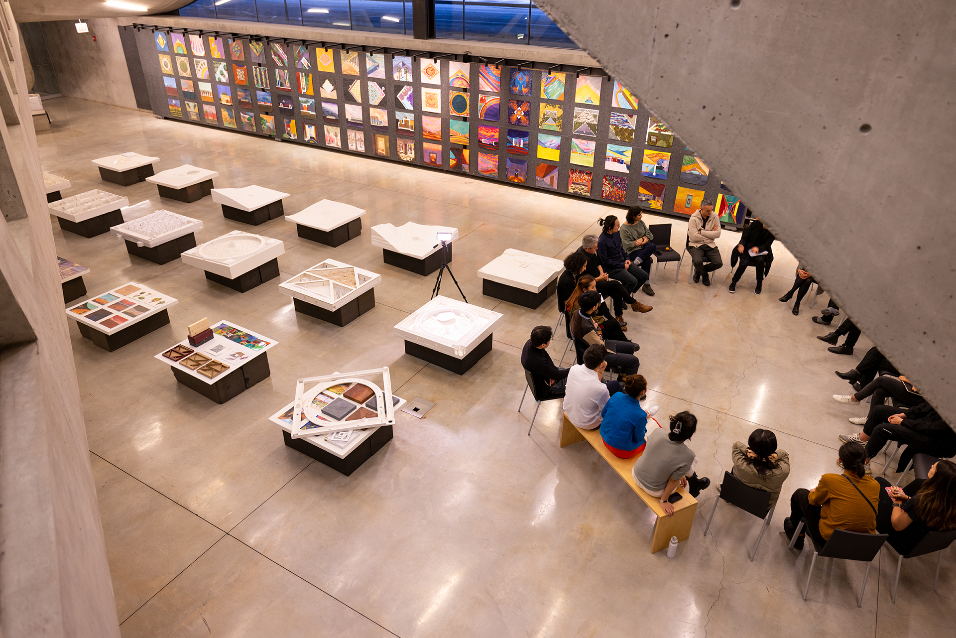 People gathered in a circle surrounded by installed artwork