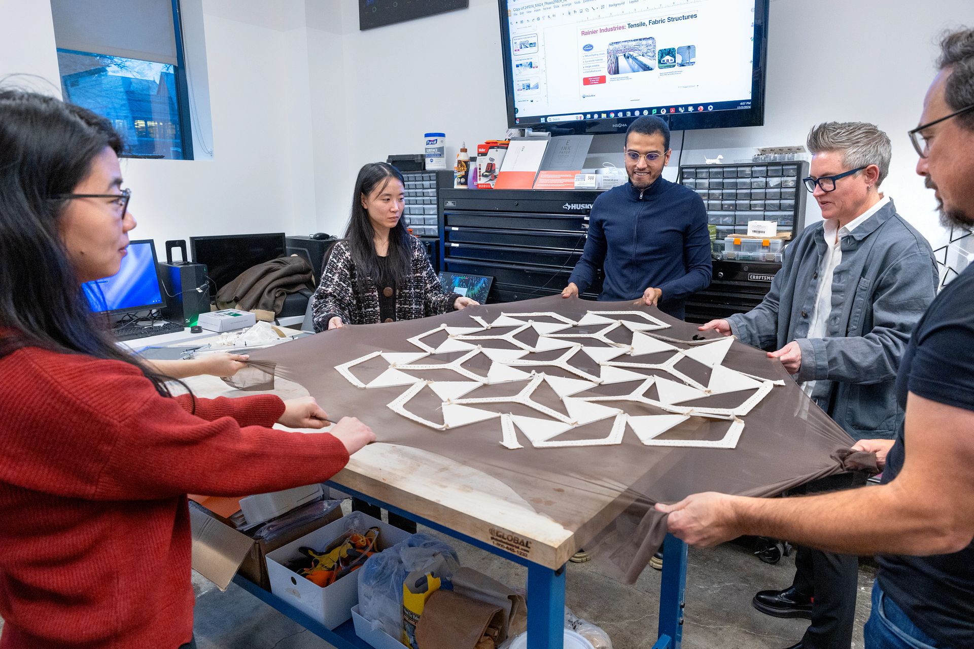 People gathered around structural model on a table