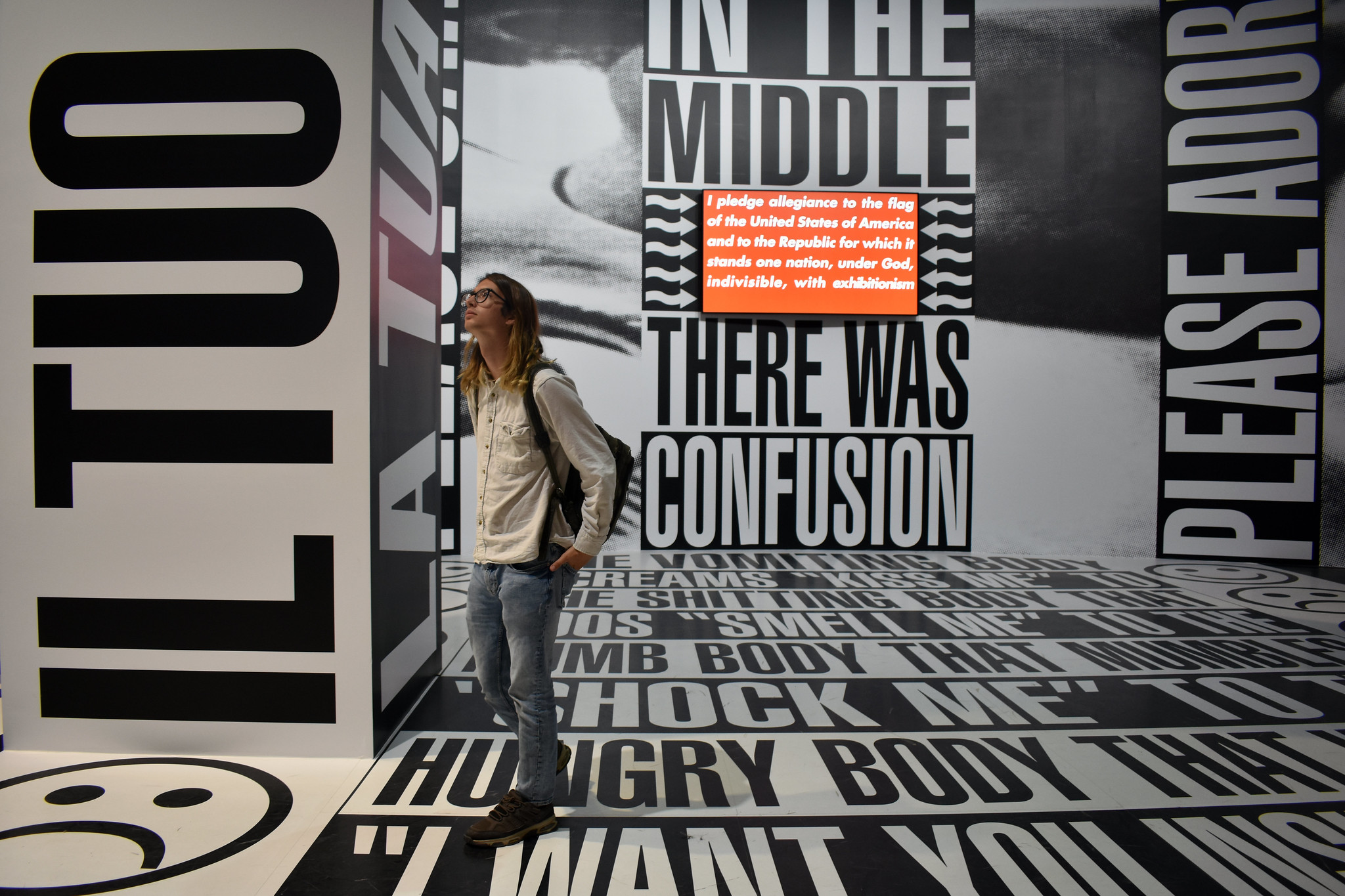 person in a gallery exhibition featuring large text on walls