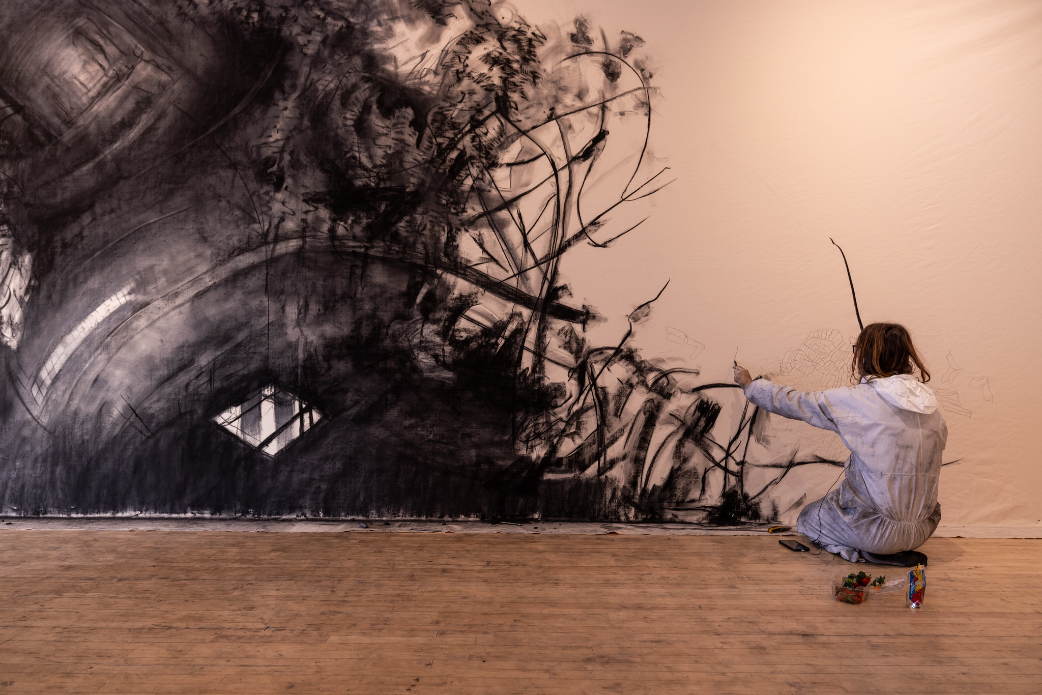 student sketching in charcoal on a gallery wall