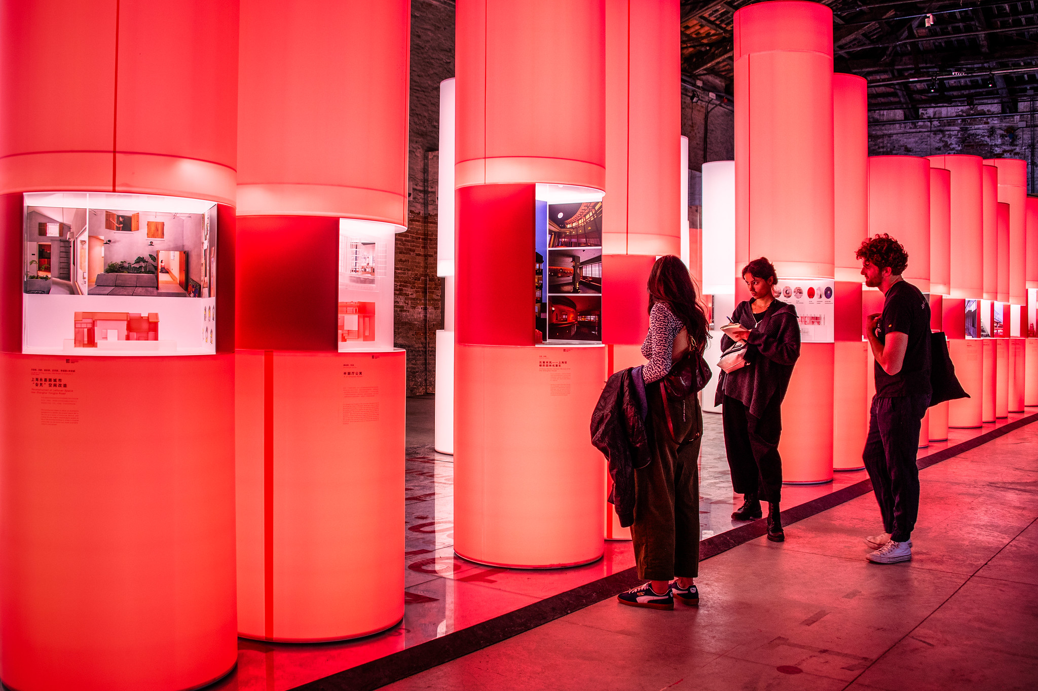 exhibition featuring brightly lit red pillars