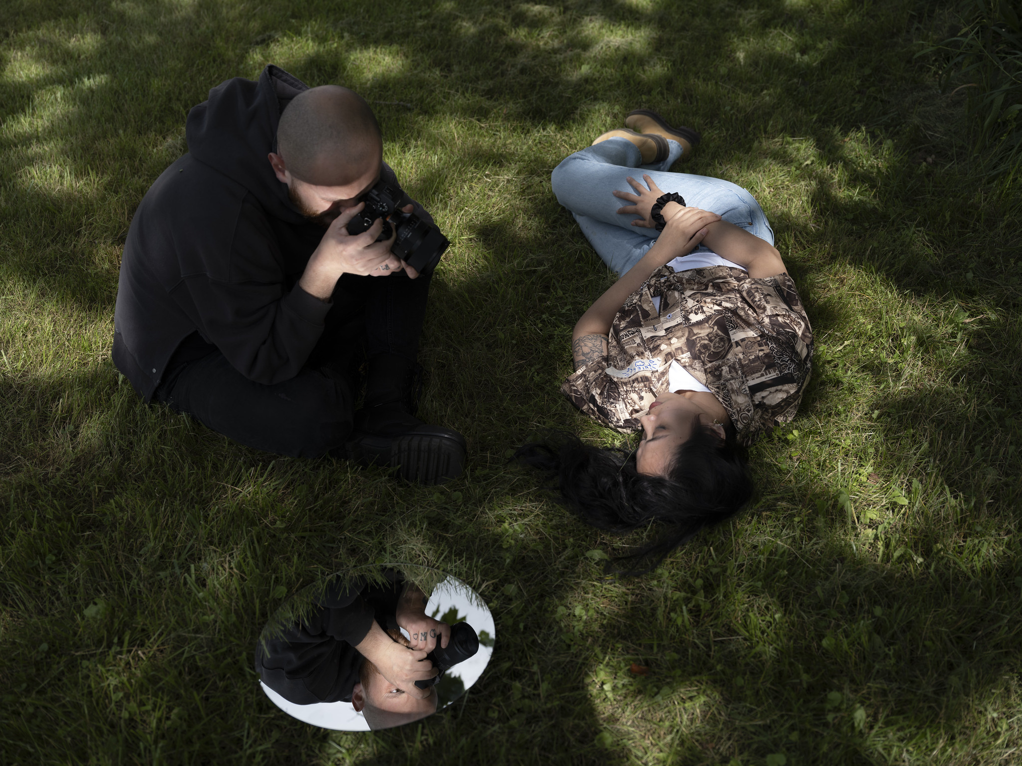 photographer making an image of a person laying in grass