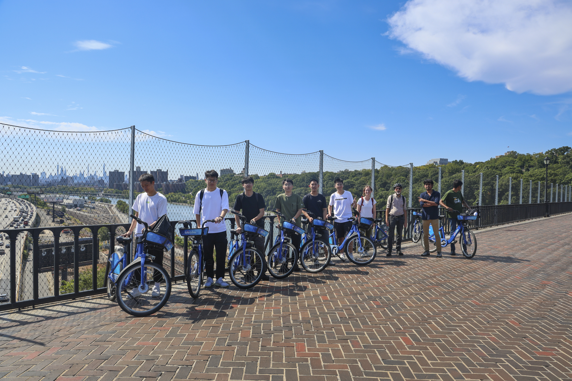 People with CitiBikes lined up along a brick road