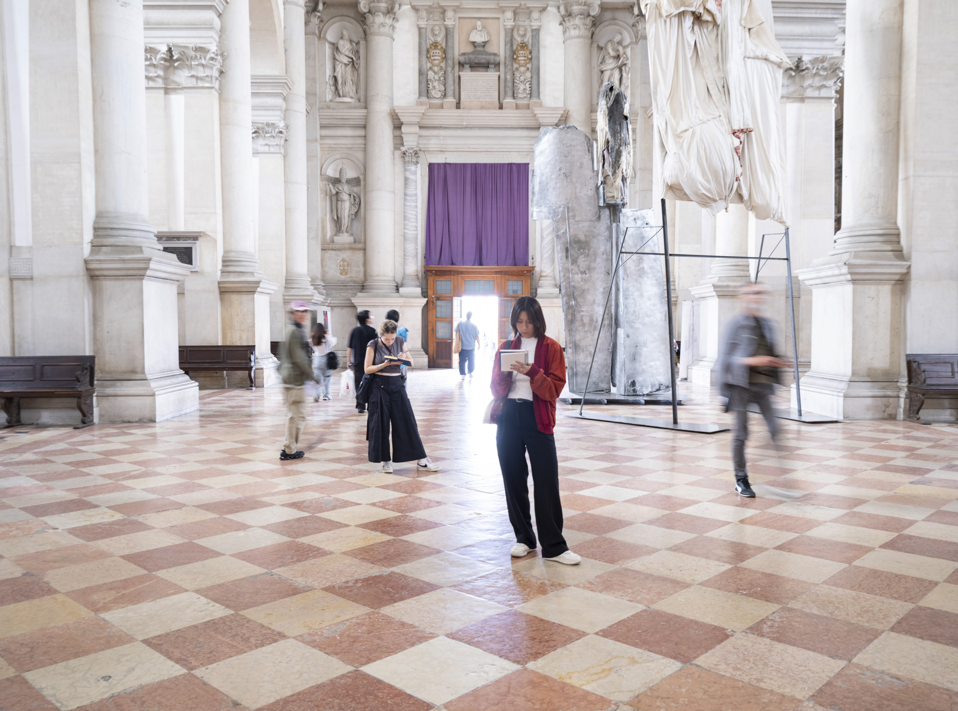 student sketching in a marble hall