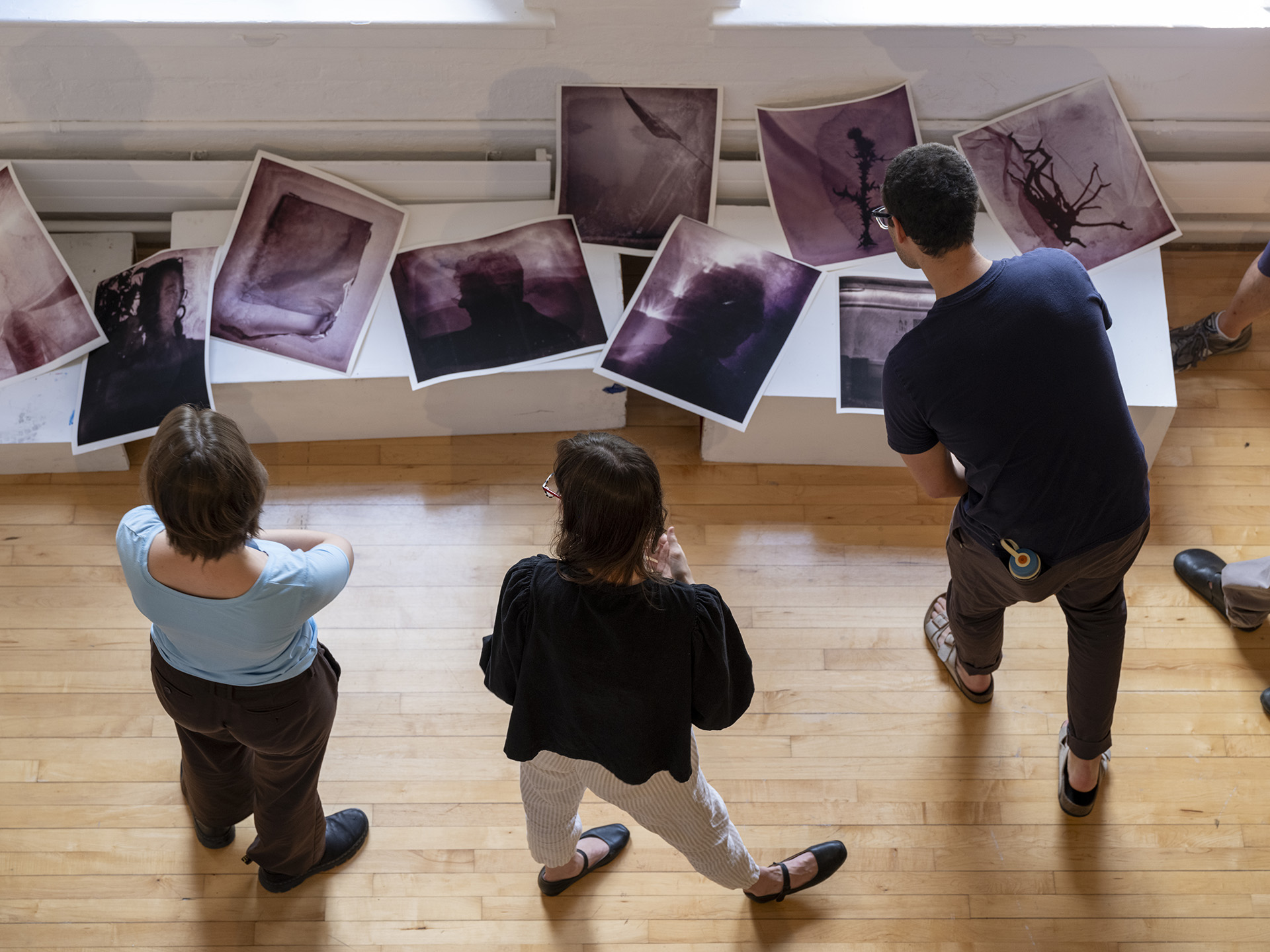 people examining a table filled with prints