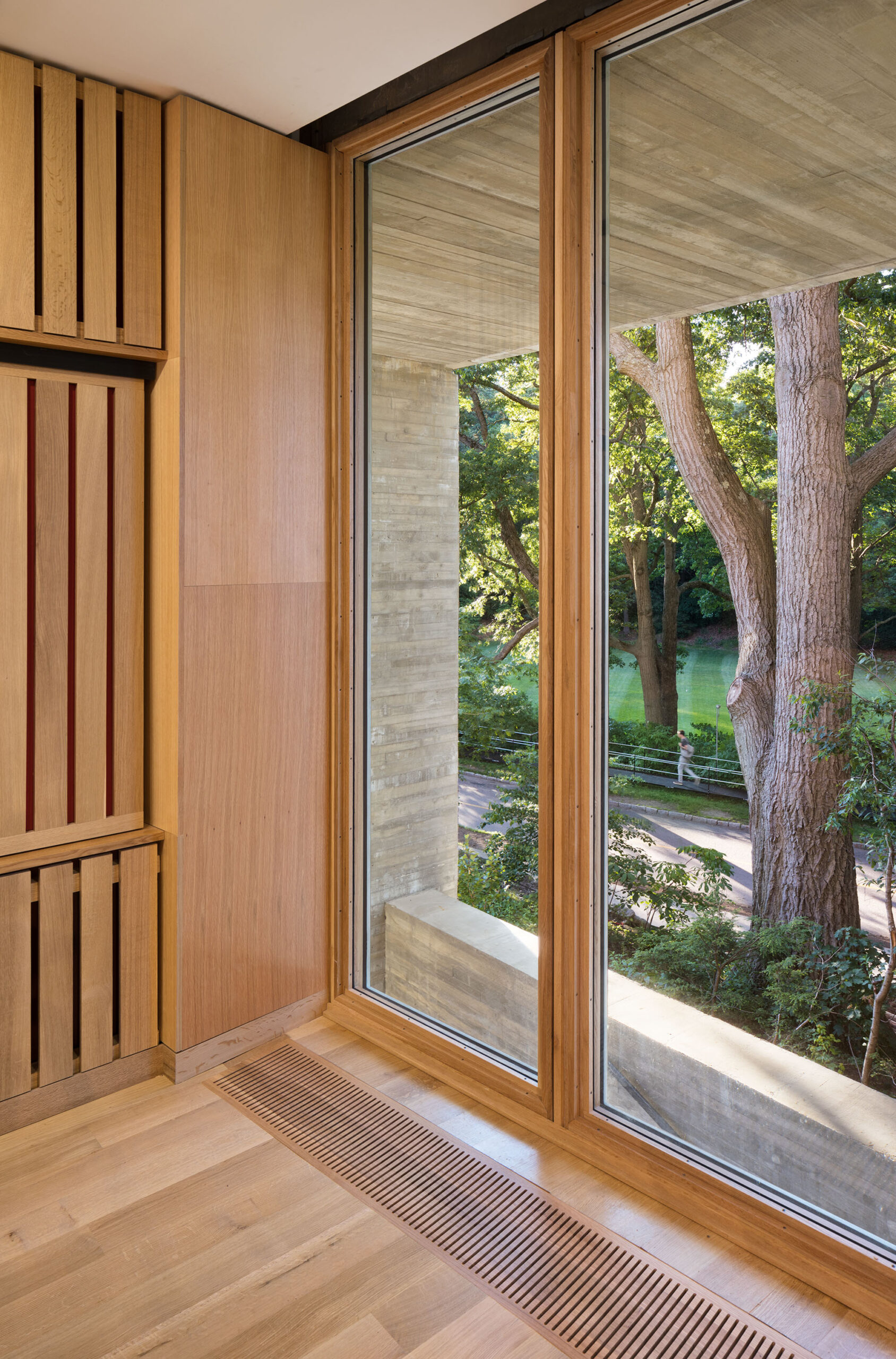 Floor-to-ceiling windows accent a room entirely clad with wood.