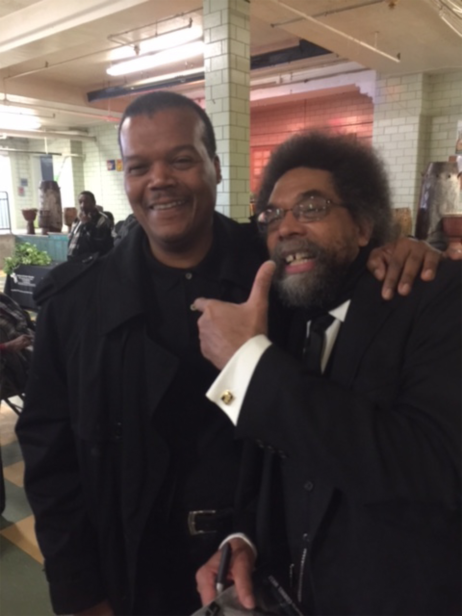 Two middle-aged Black men pose for a photo.