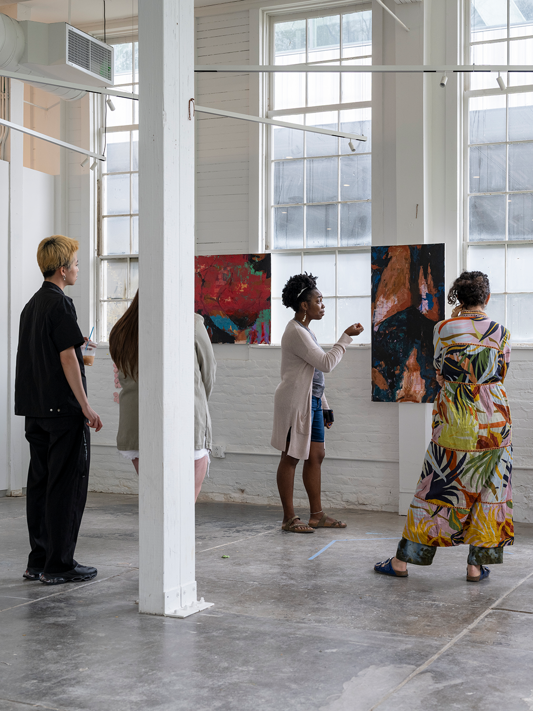 people viewing hung paintings