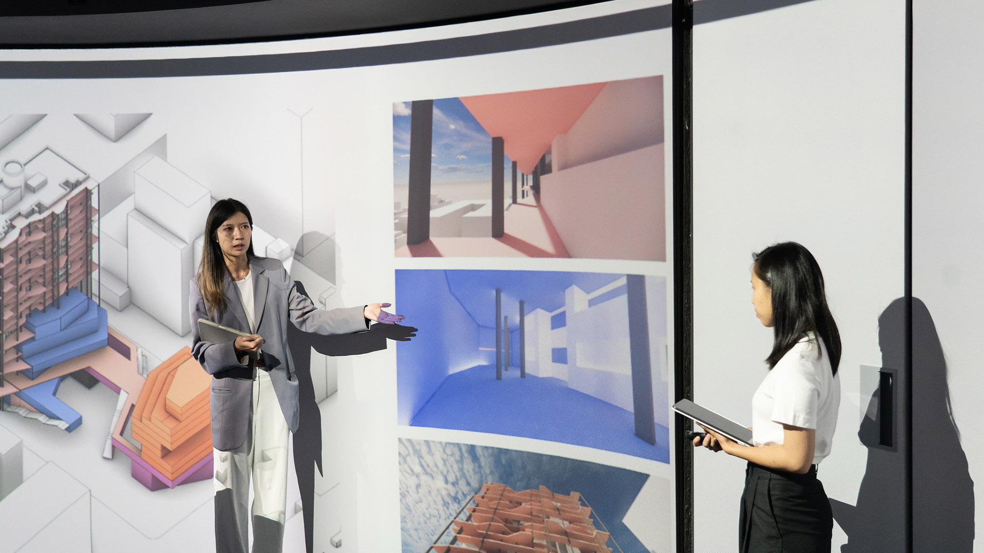Two people present a series of architectural drawings.