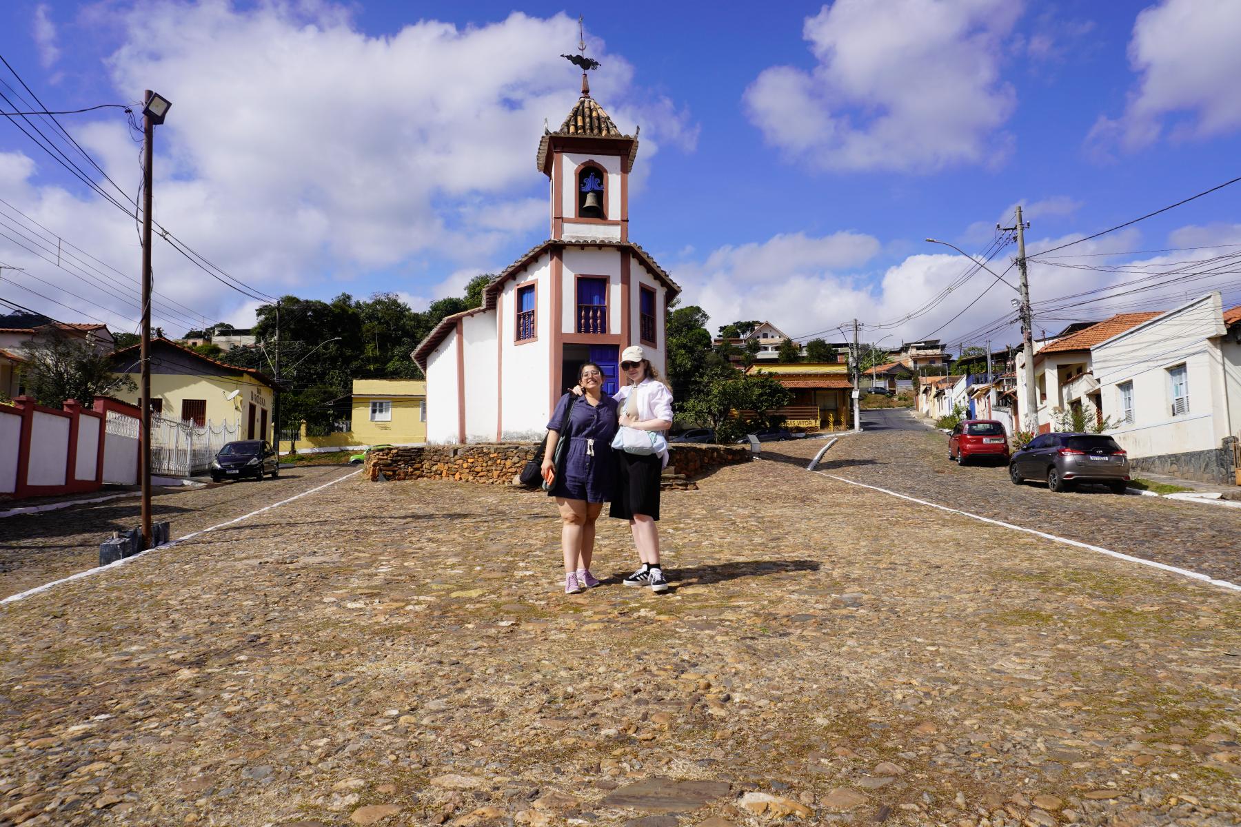 People standing in front of a bell tower in Brazil.