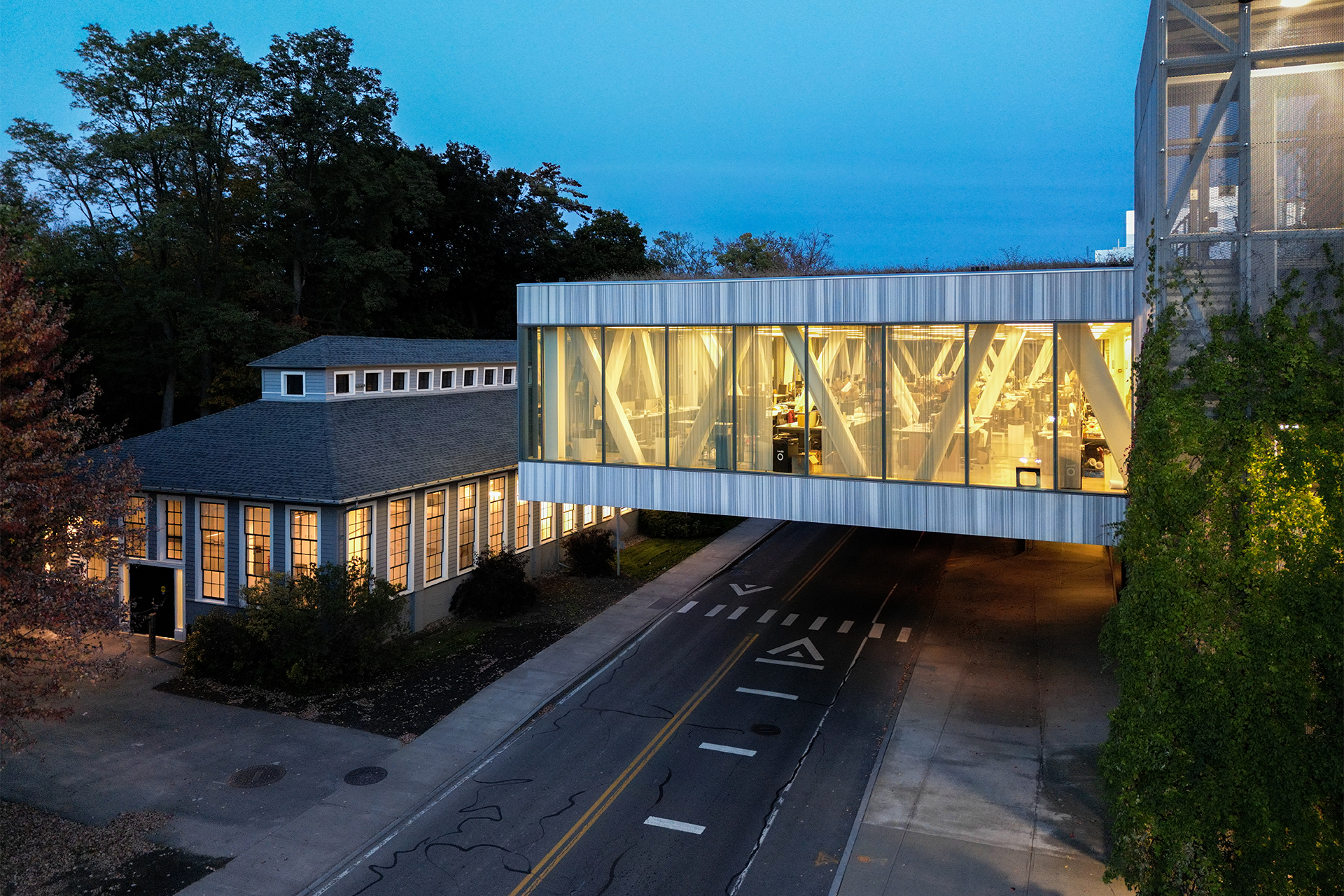 Exterior of a cantilevered building illuminated at night.
