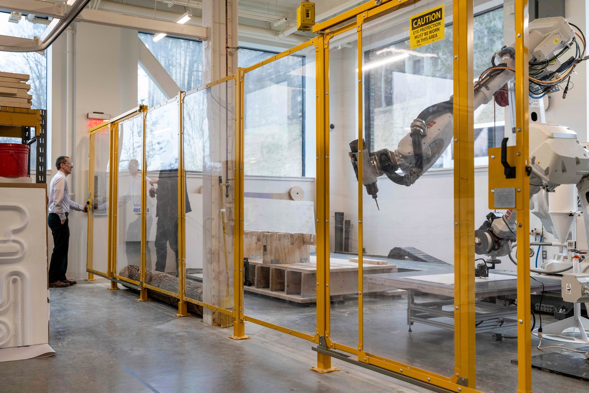 Two people converse next to a large robotic machine.
