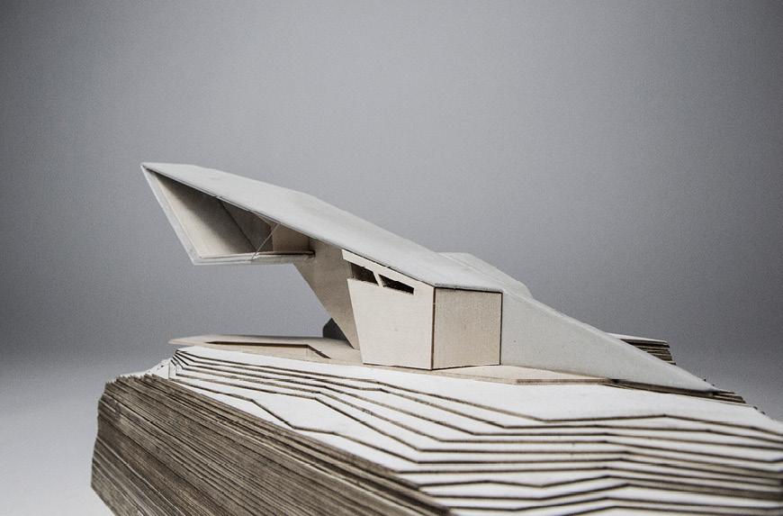 Closeup photographic of an angular architectural model with a steep landscape.