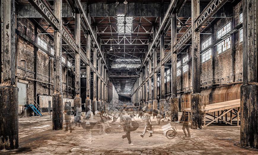 Digital rendering of the interior of a factory with people carting supplies around the space.