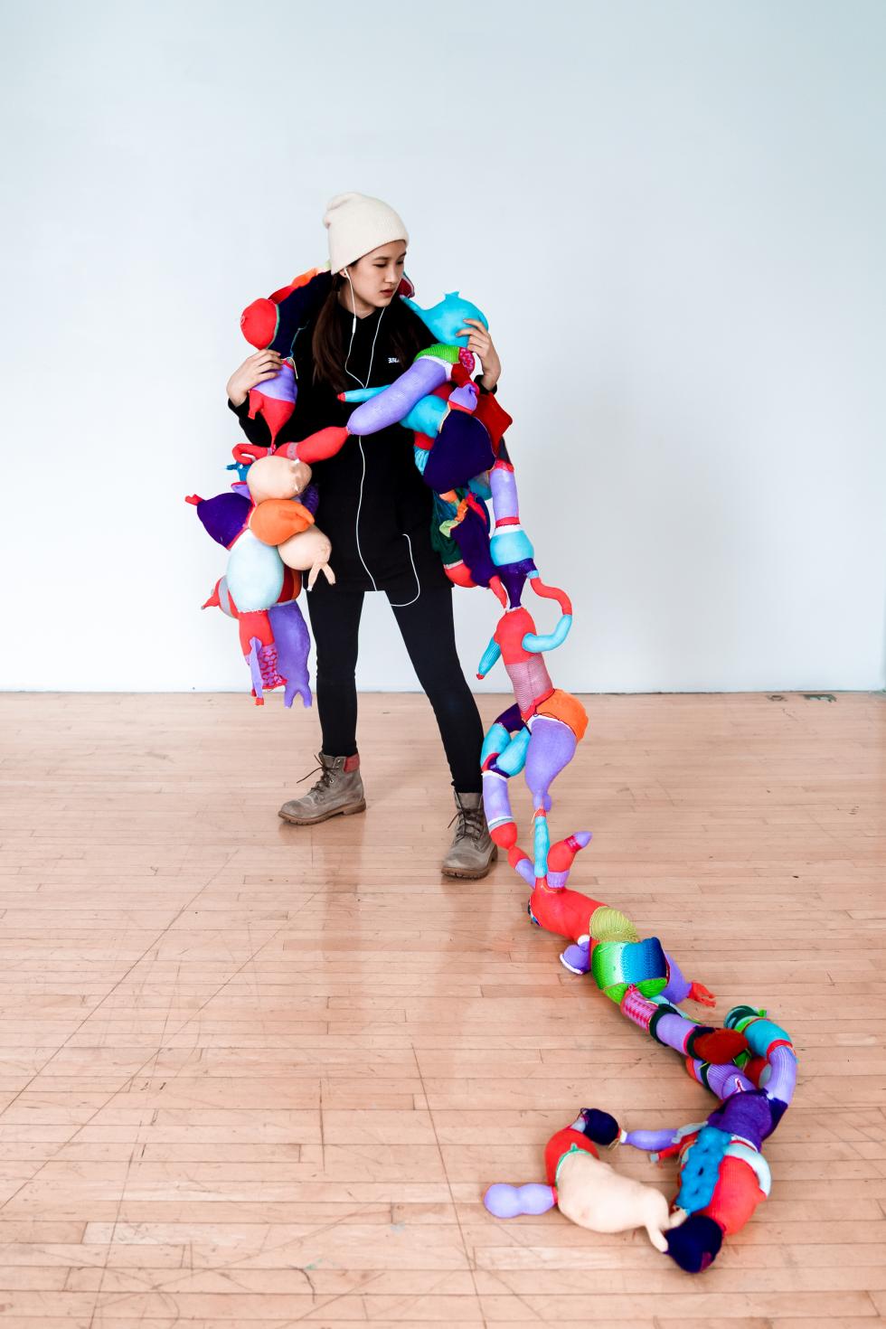 A personal holding a long fabric sculpture.