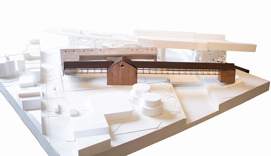 Three dimensional model of a site with a few detailed wood buildings and bridges.