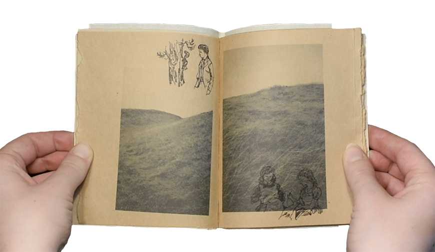 A person opens a book to two pages that have a hill landscape with overlaid illustrations of people.