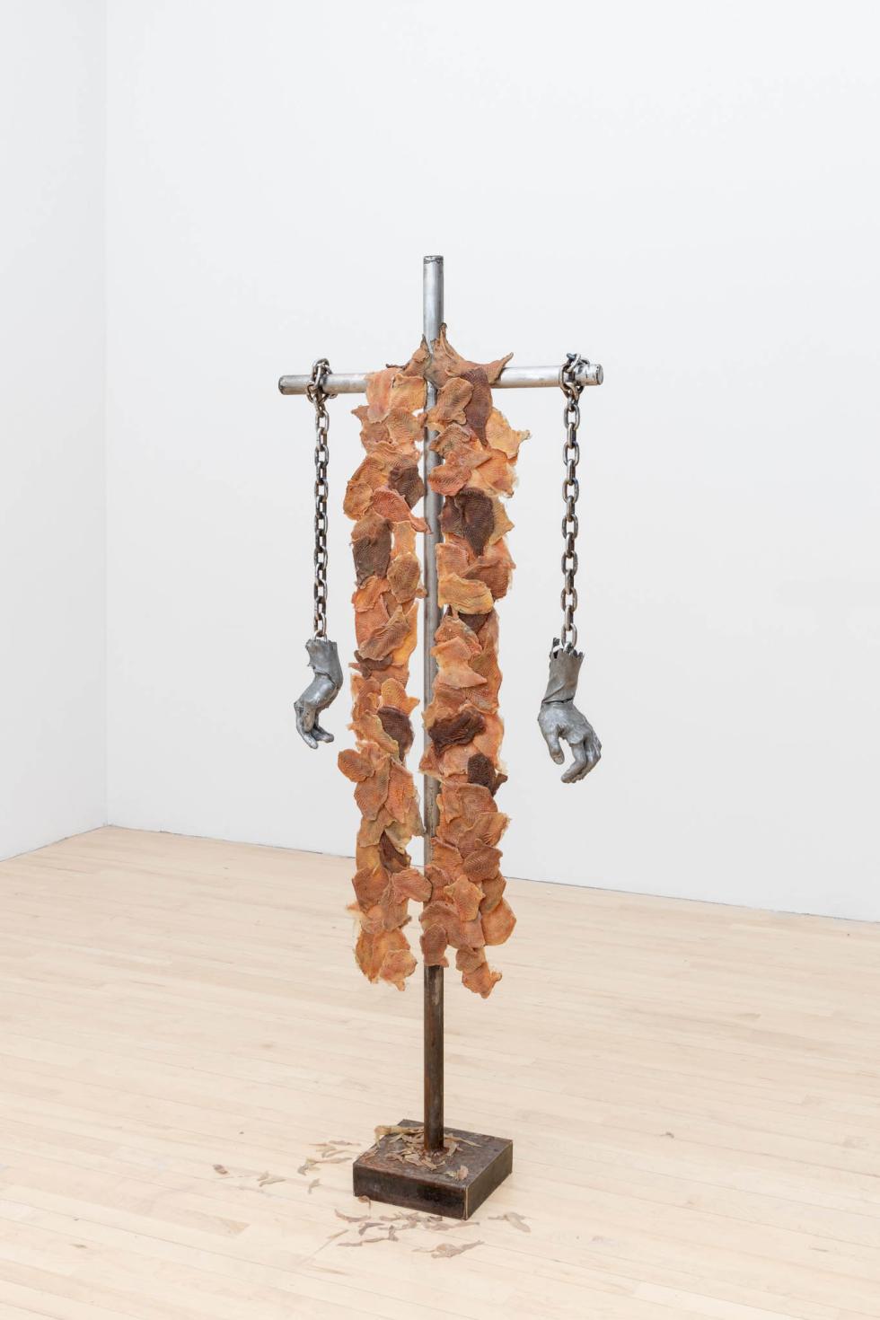 A wood and metal sculpture with silicone chicken skins attached to it.