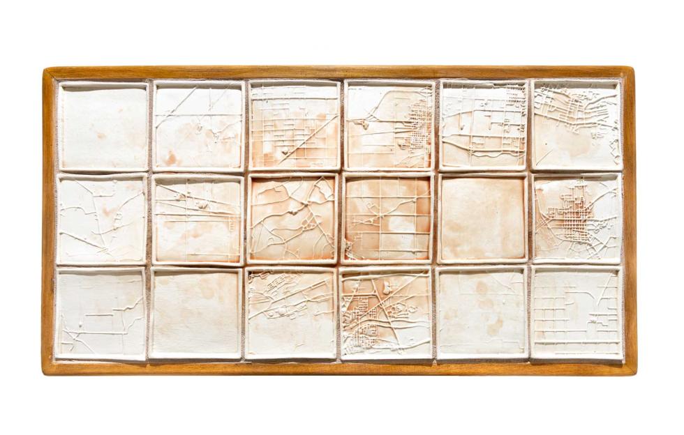 A series of white ceramic tiles with map designs.