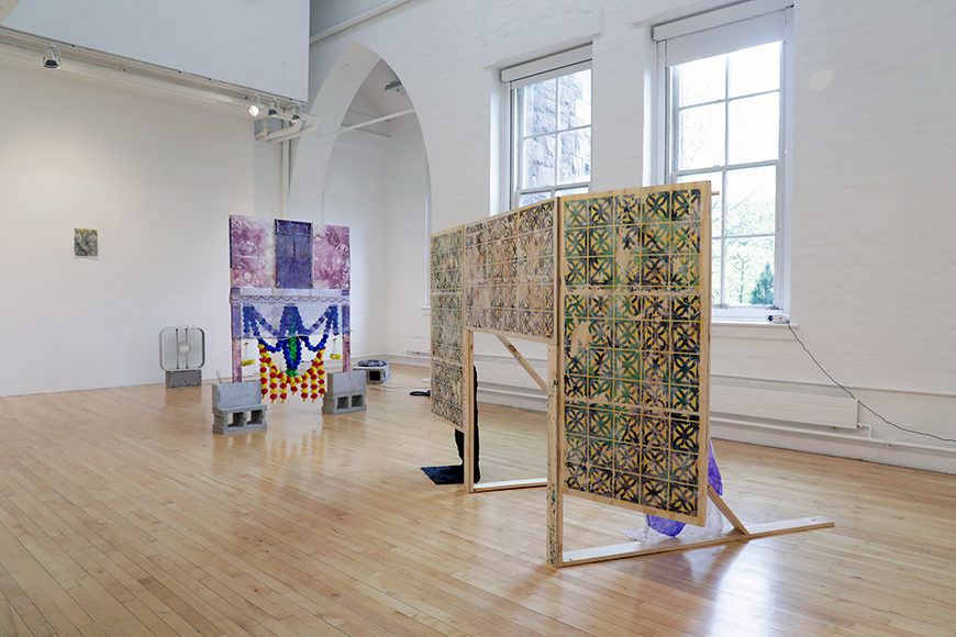 Wood panel sculptures with prints and fabric that are displayed throughout a gallery.