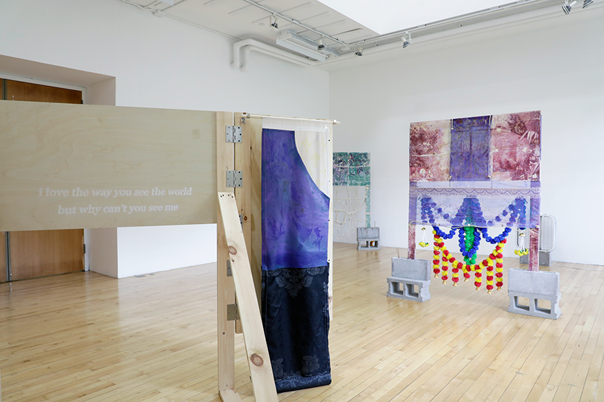 Installation view of wooden sculptures on cinder blocks.