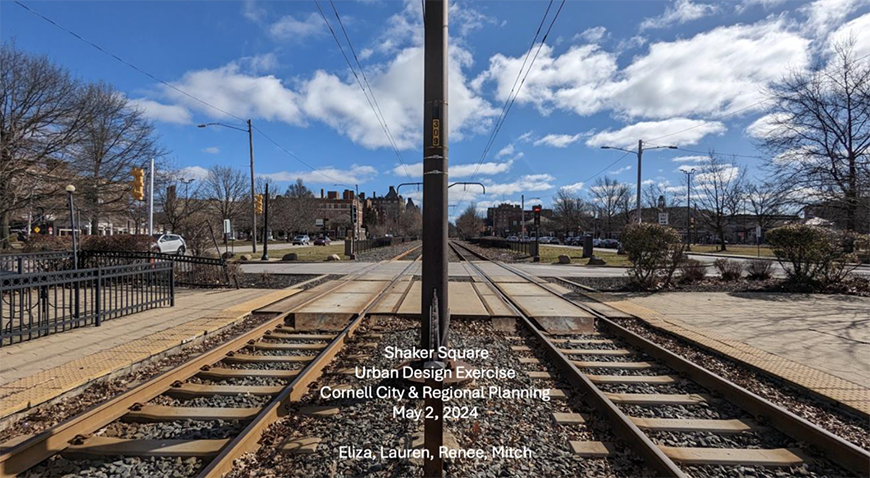 Two railroad tracks with a pole in the center and a blue sky in the background.