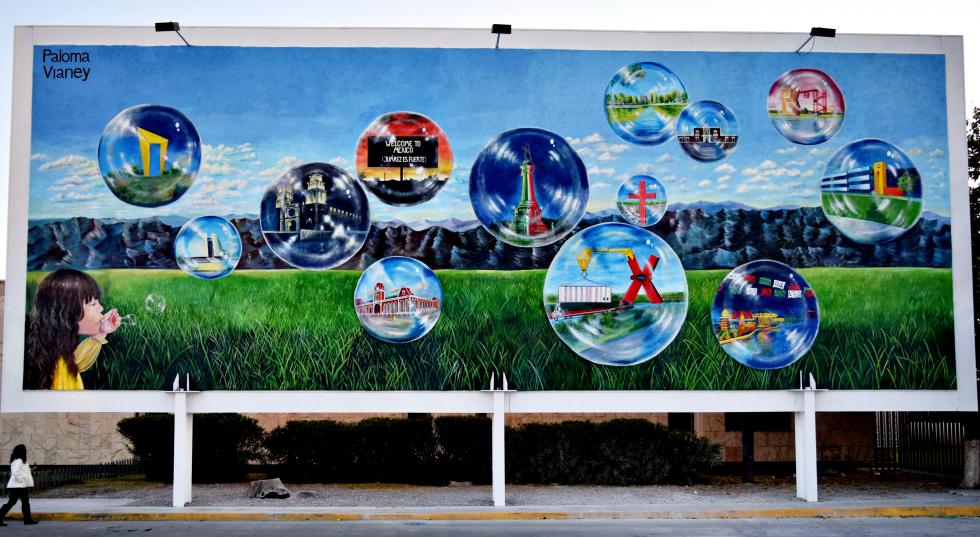 A painting of a landscape on a billboard with bubbles that showcase different scenes.