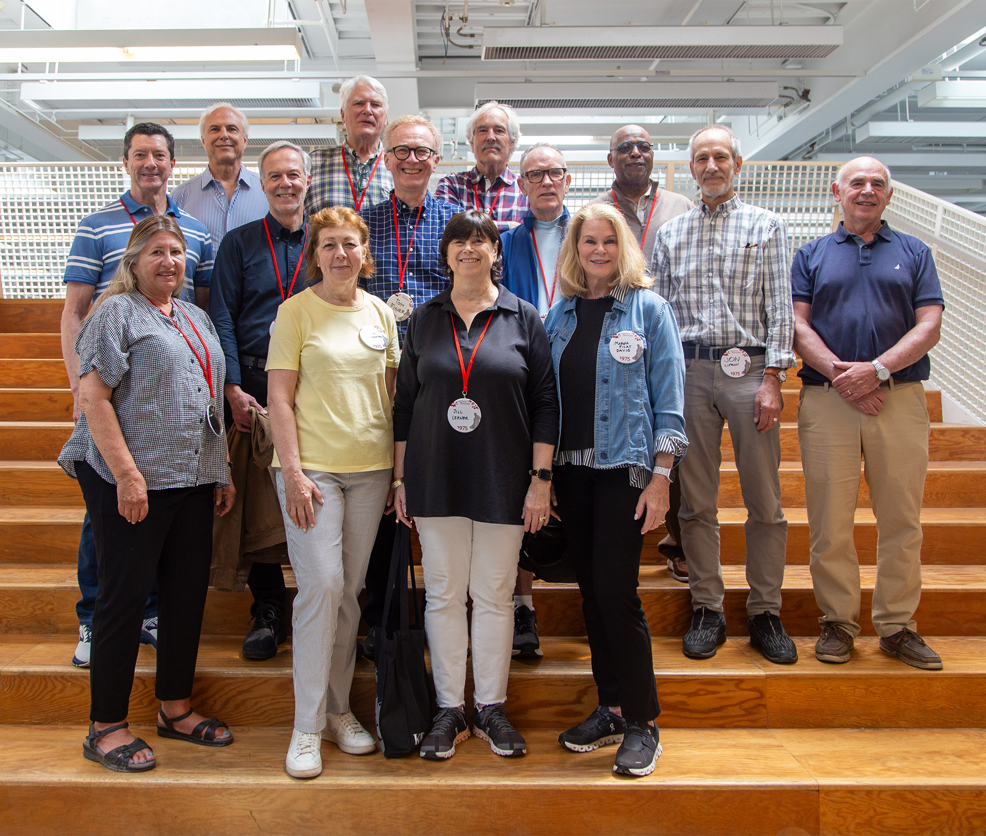 Group of people stand on a staircase and pose for a photo.