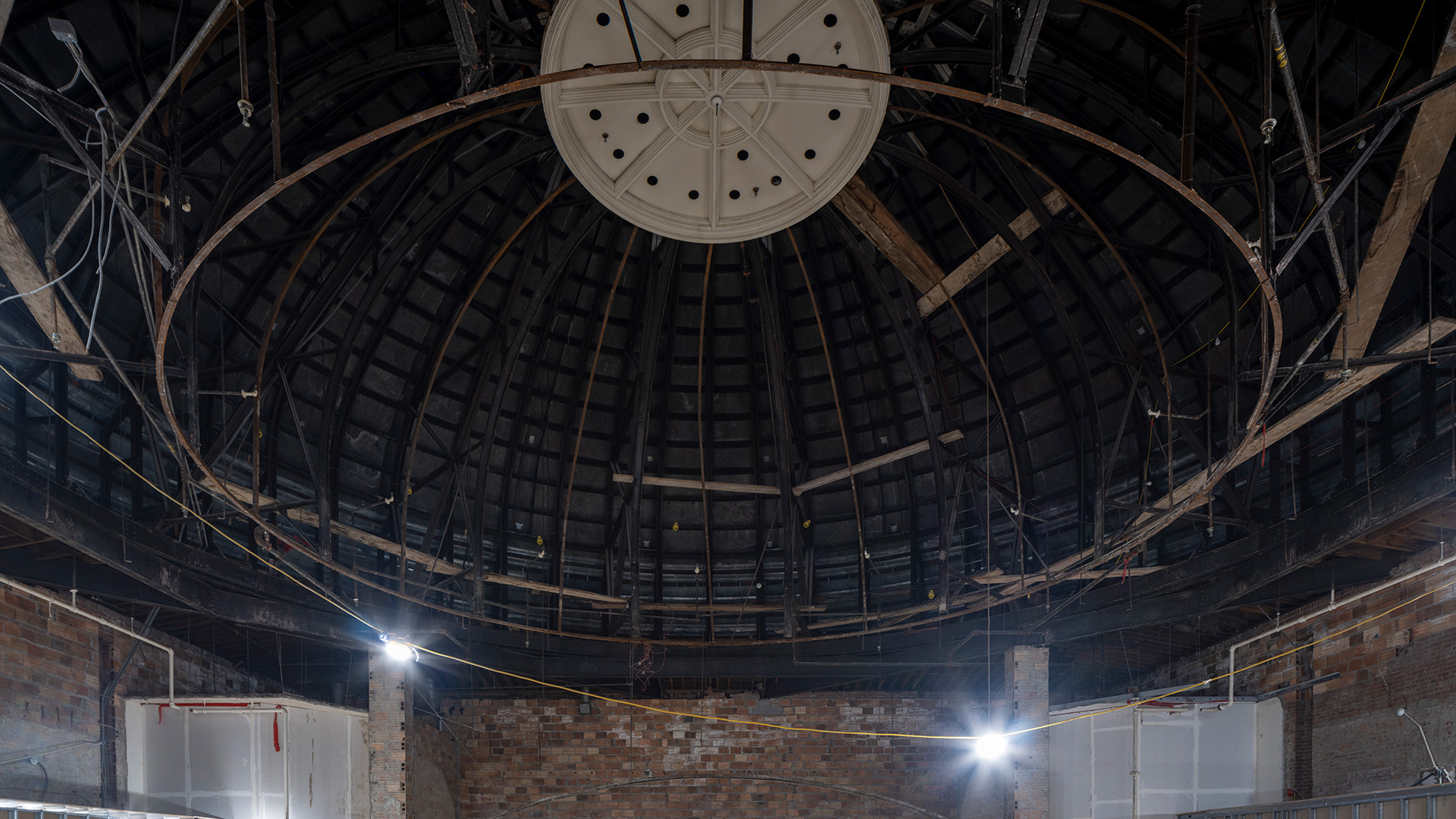 Interior of a building looking upward toward a dome with exposed framing.