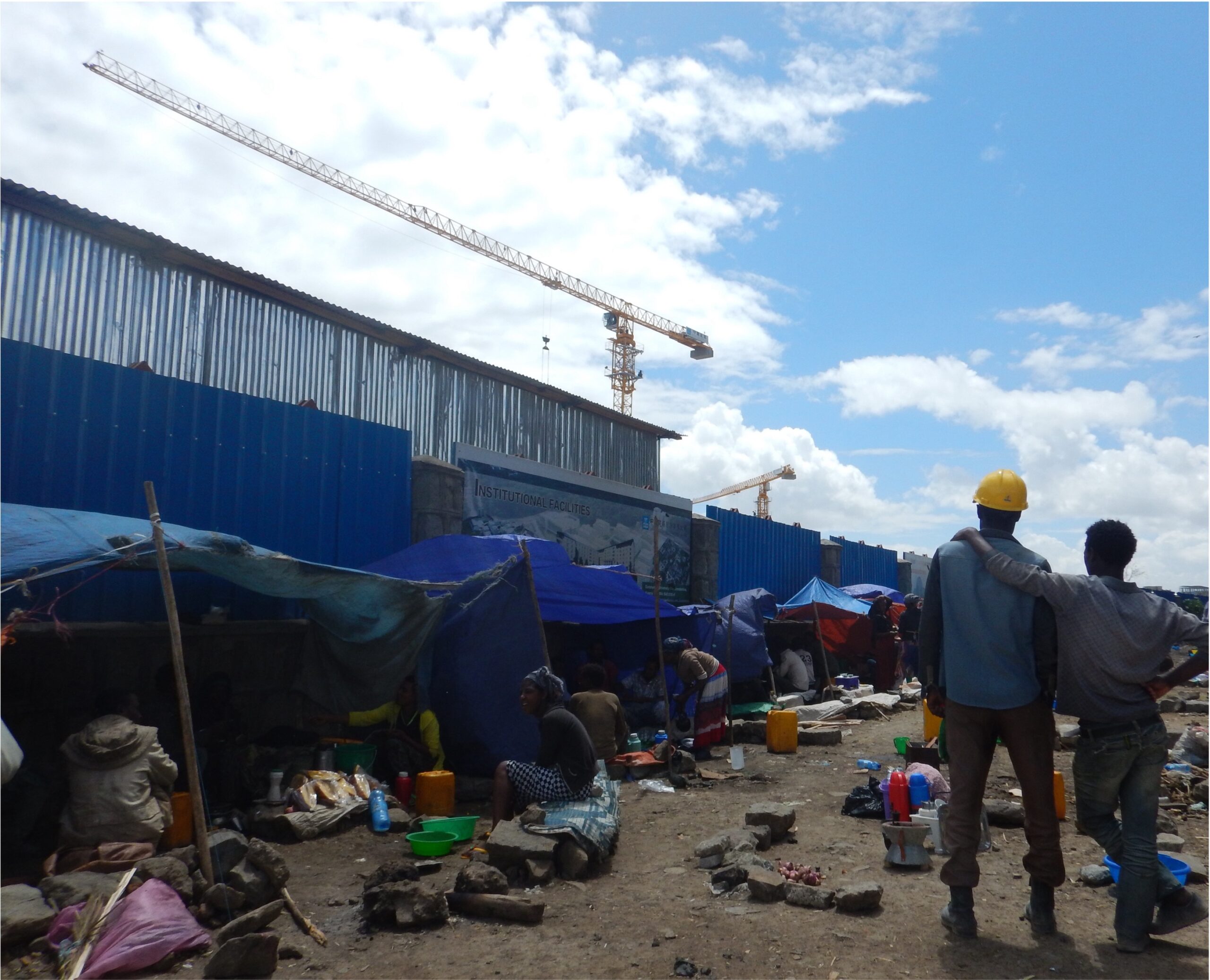 Informal shelters line a construction site