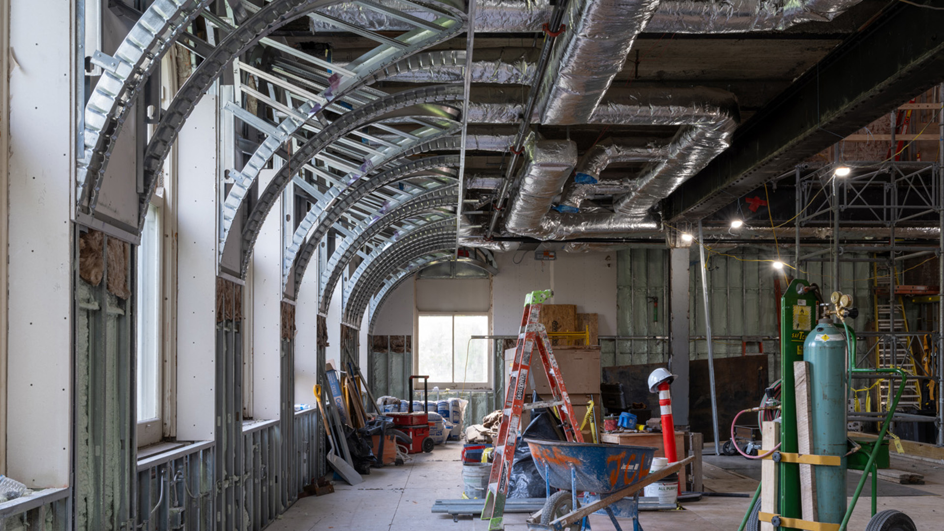 Interior of a building showing the metal scaffolding inside the archways of the windows.
