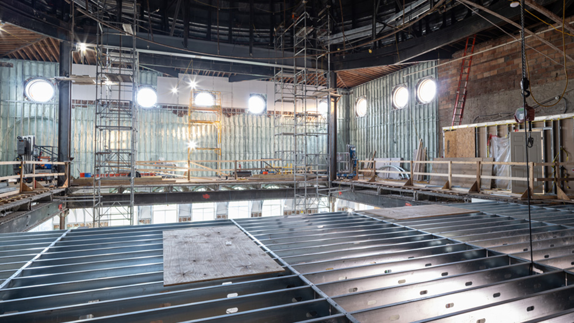 Interior of a building with exposed wood studs and exposed metal floor framing.