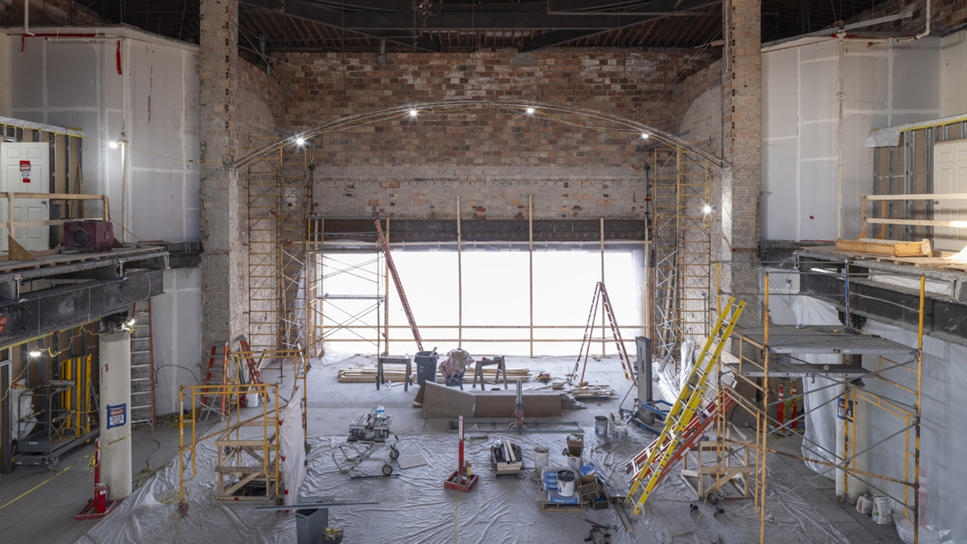Interior of a brick walled building with a large cut out for a metal window.