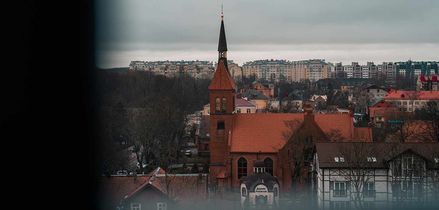 Preserved church steeple amidst modern apartments.