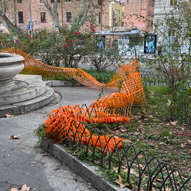 Orange construction webbing lining a public park path.