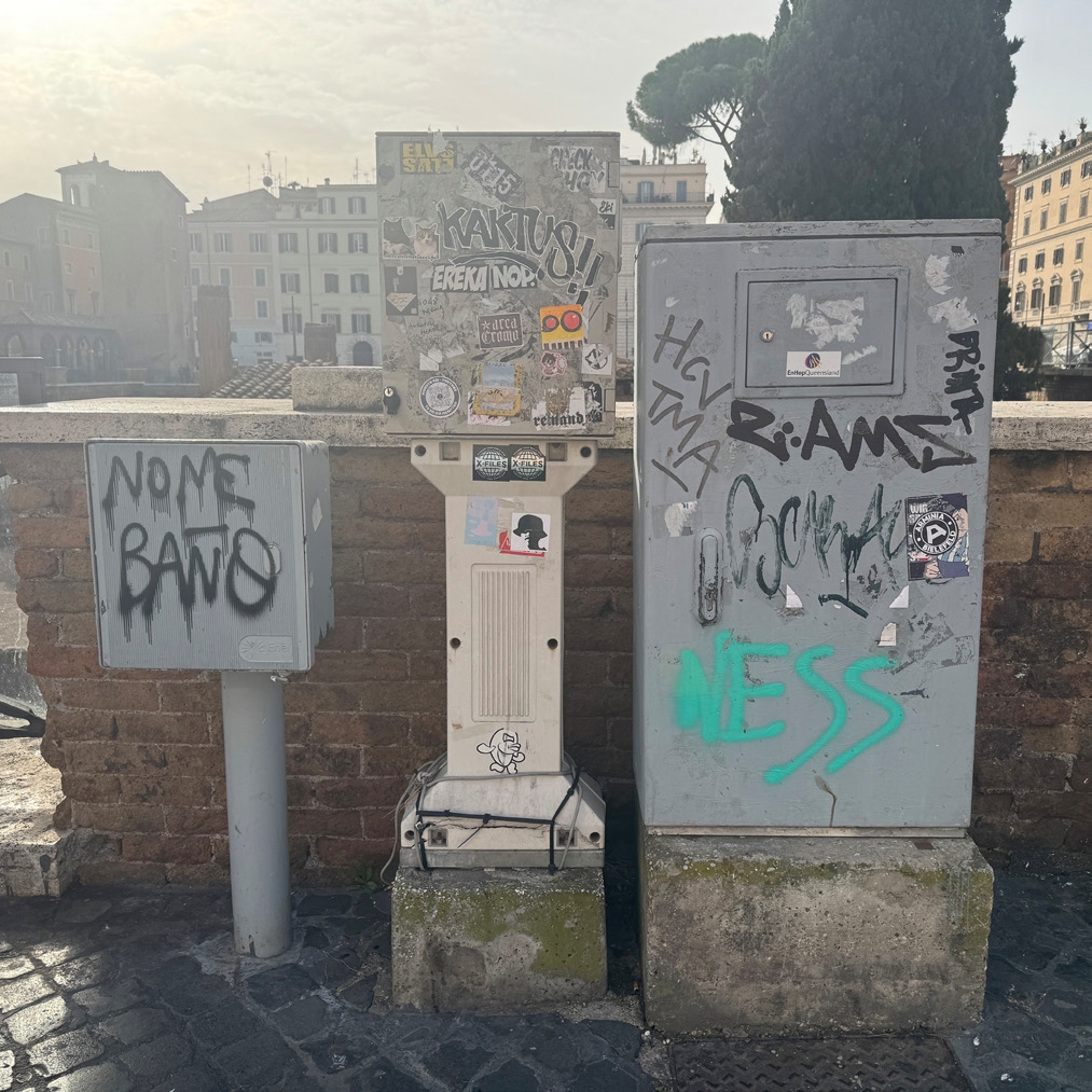 Three industrial meters have graffiti covering them.