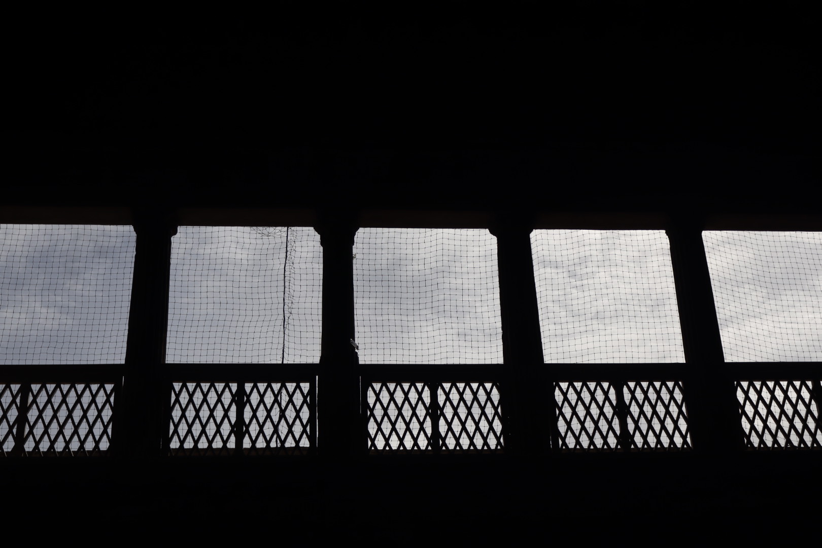 columns in shadow with white clouds in the background